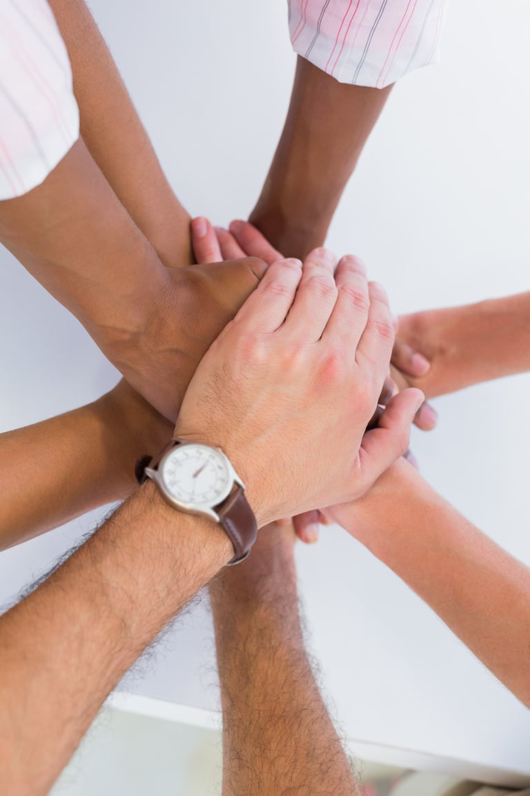 Team members putting hands together